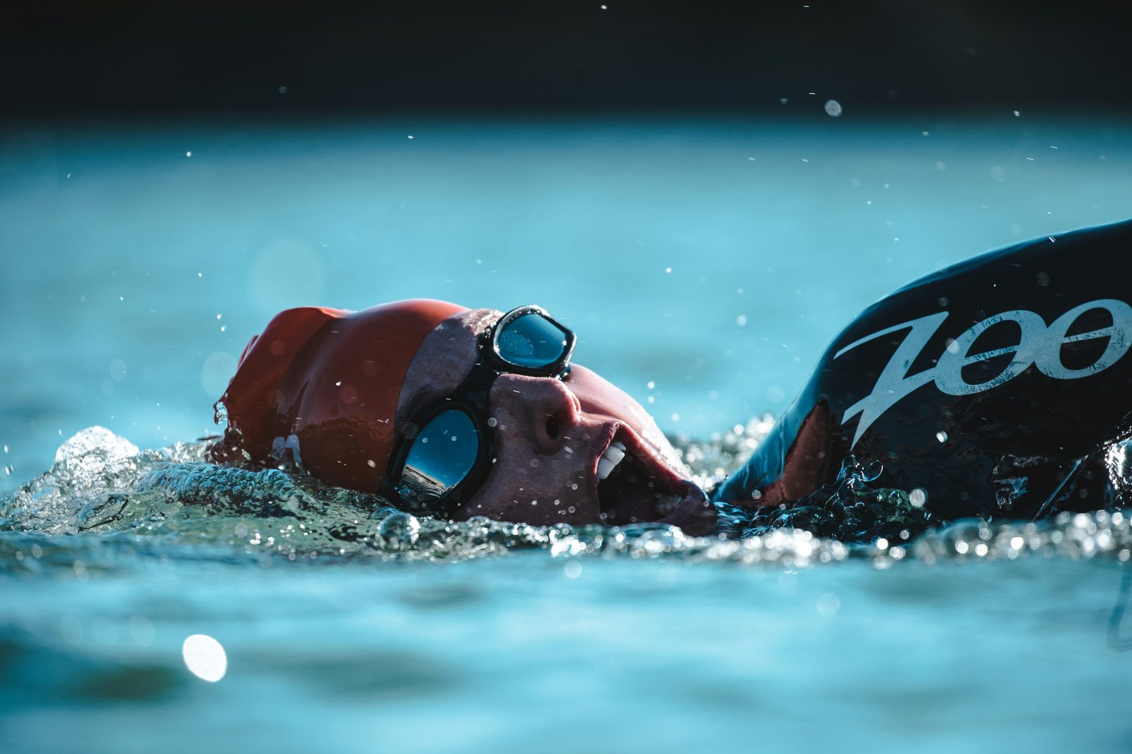 An open-water swimmer mid-stroke in a wetsuit